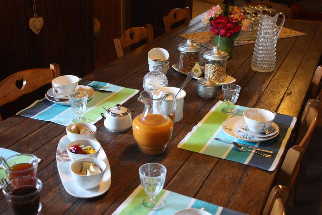 - une table en bois avec de la nourriture et du jus d'orange dans l'établissement Le Degoutaud, à Le Barroux