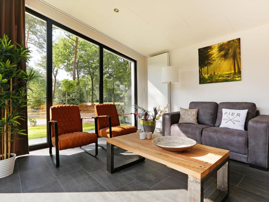 a living room with a couch and a table at Wellness Forest Retreat in Markelo