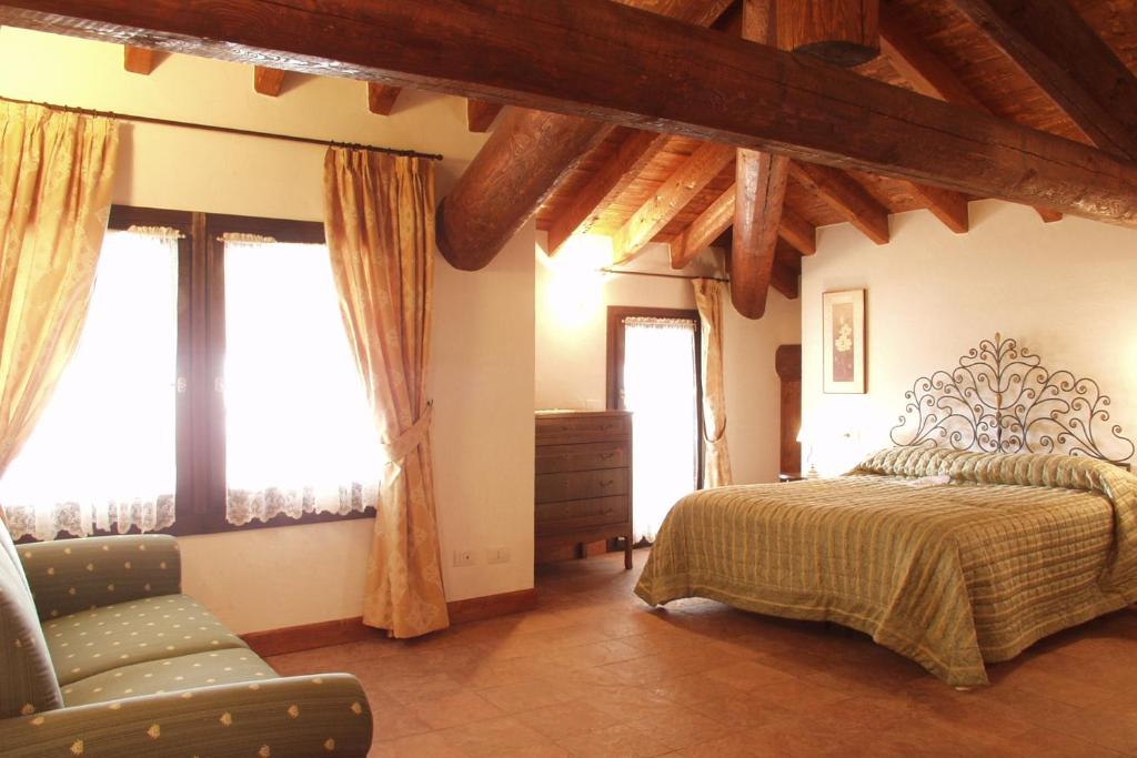 una camera con letto, sedia e finestre di Bed and Breakfast Zanaglio a Borno