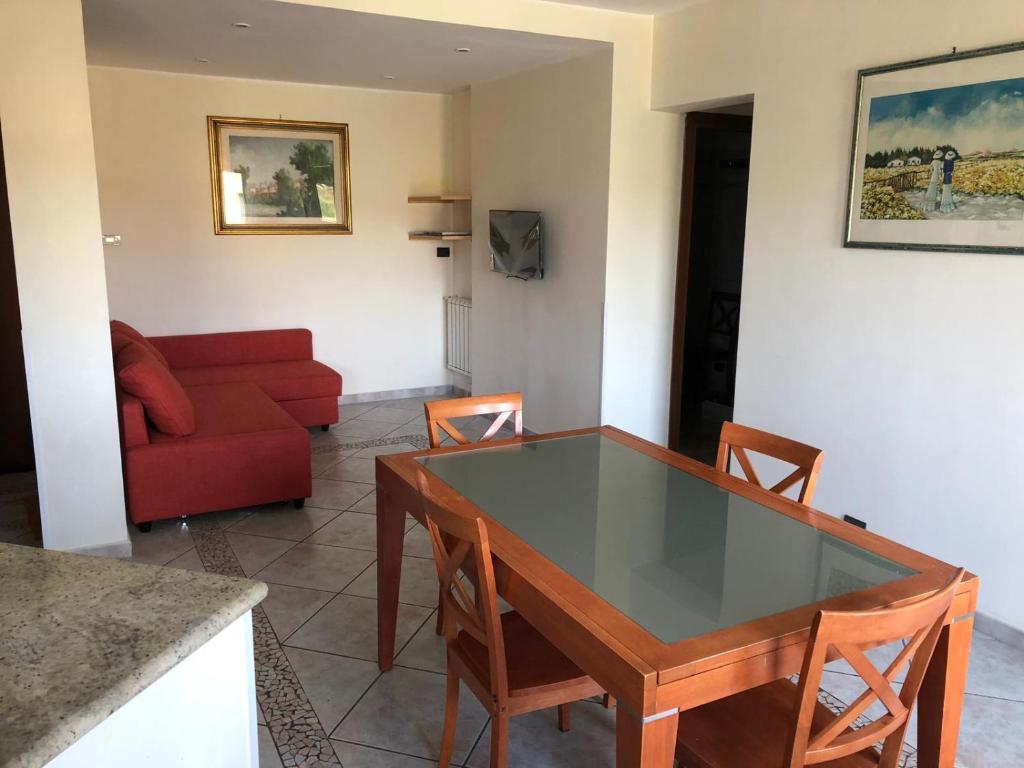 ein Wohnzimmer mit einem Tisch und einem roten Sofa in der Unterkunft Marco simone golf club in Marco Simone