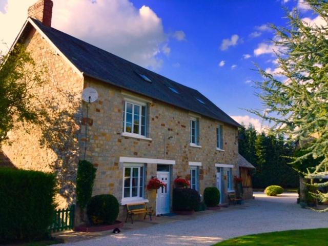 une grande maison en briques avec un toit noir dans l'établissement Bonsentier, à Barenton