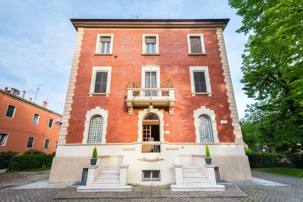 un gran edificio de ladrillo rojo con balcón en Villa Savioli Room & Breakfast, en Bolonia