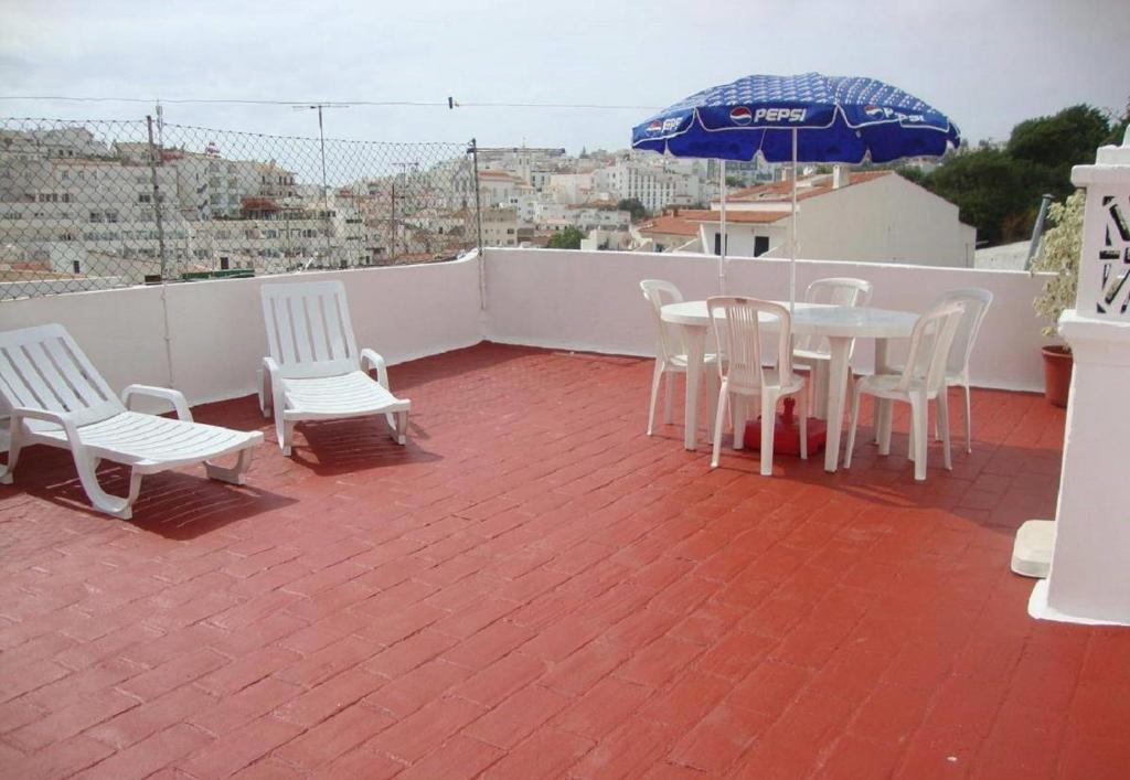 a patio with a table and chairs and an umbrella at Travessa Albufeira Apartments by Umbral in Albufeira