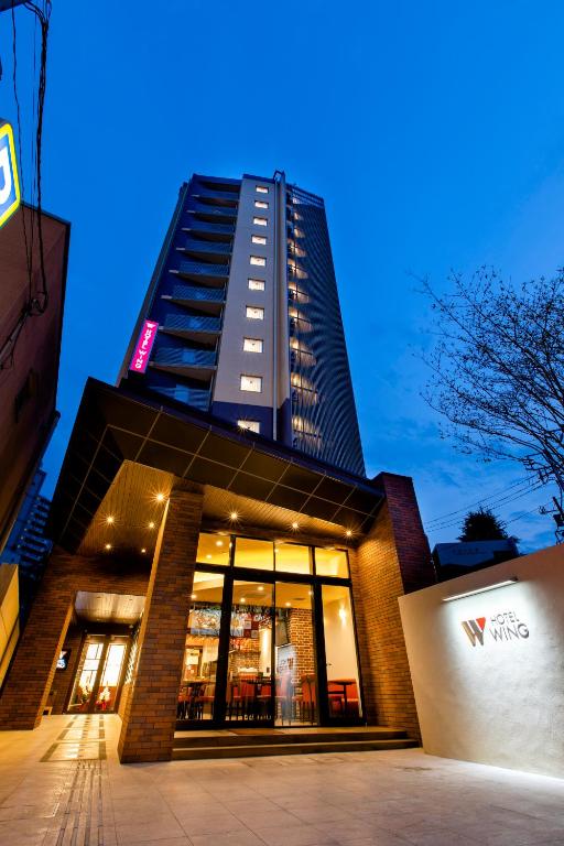 a tall building with a sign on top of it at Hotel Wing International Tokyo Akabane in Tokyo