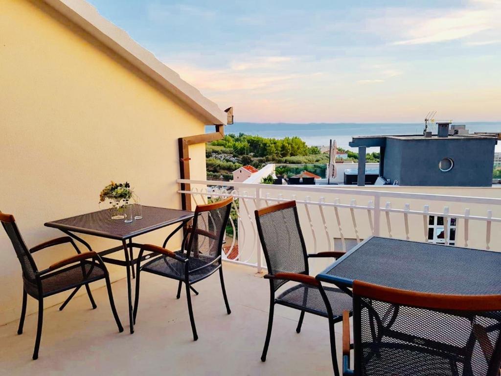 a patio with tables and chairs on a balcony at Pension Alba in Podstrana