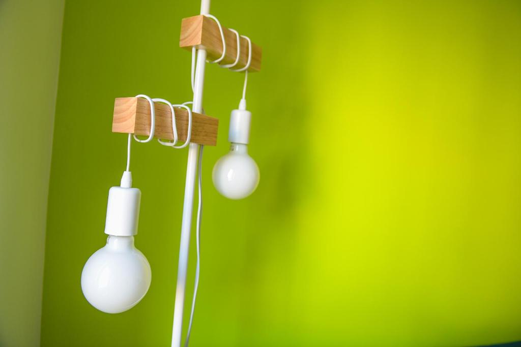 a group of lights hanging from a green wall at Puzzle Apartment in Dedinje