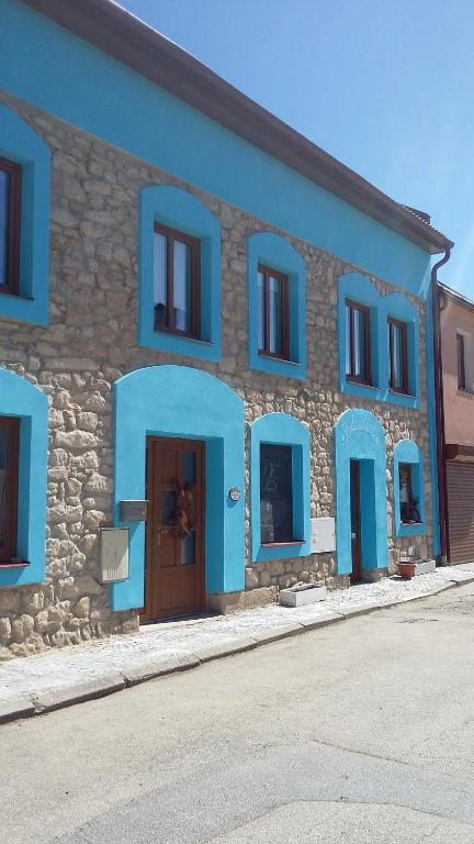 un bâtiment avec des portes et des fenêtres bleues dans une rue dans l'établissement Penzion L´isola, à Kunžak