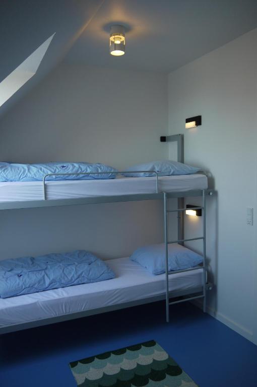 two bunk beds in a room with a ceiling at Femmasteren Hotel & Hostel in Marstal