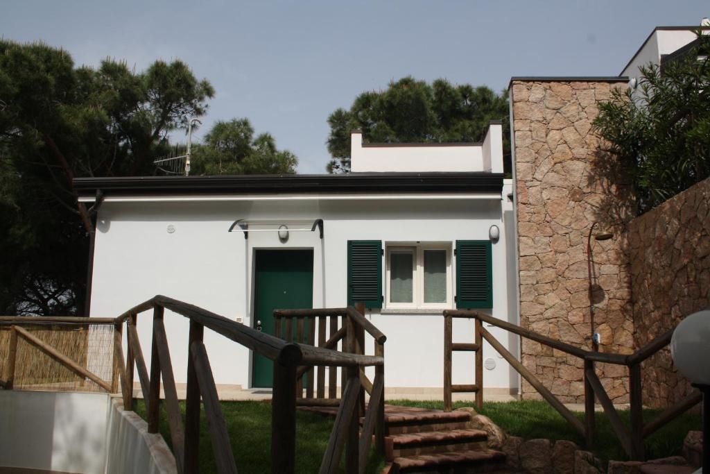 una casa bianca con una porta verde e scale di Rosa Dei Venti a Valledoria