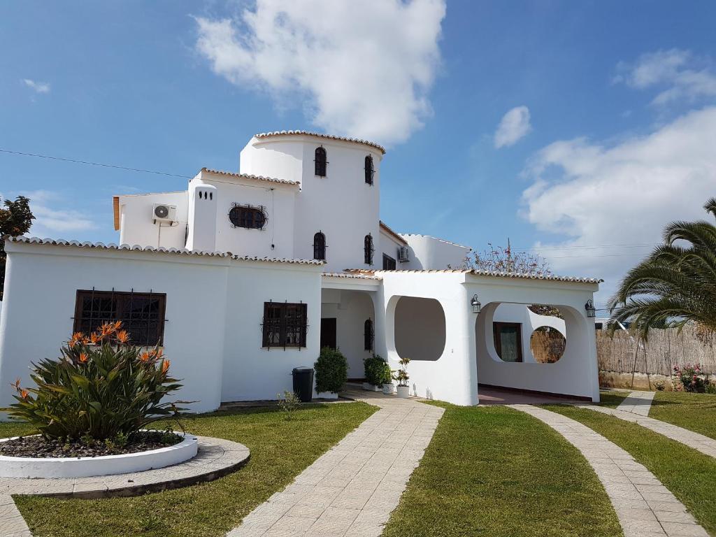 a white house with a grass yard at Vila Caixinha in Armação de Pêra