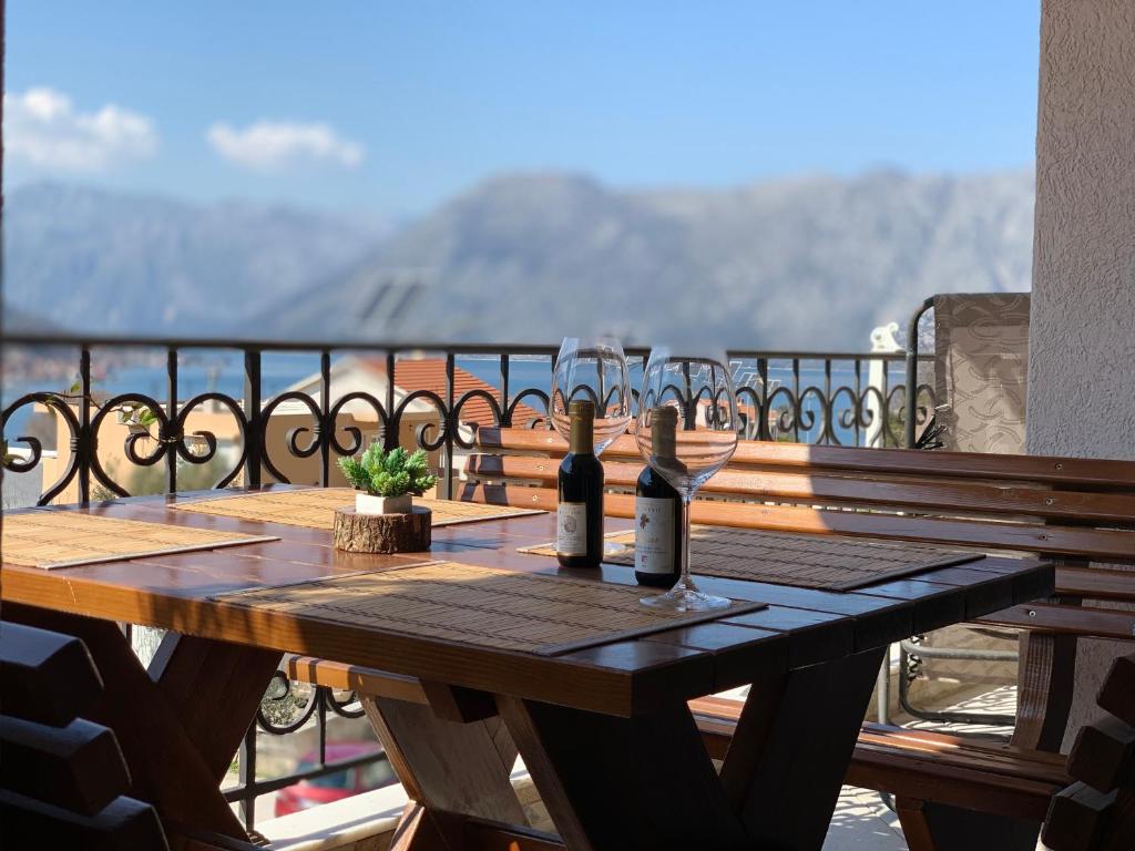 un tavolo in legno con bicchieri da vino sul balcone di Apartment Stella di Cattaro a Kotor (Cattaro)