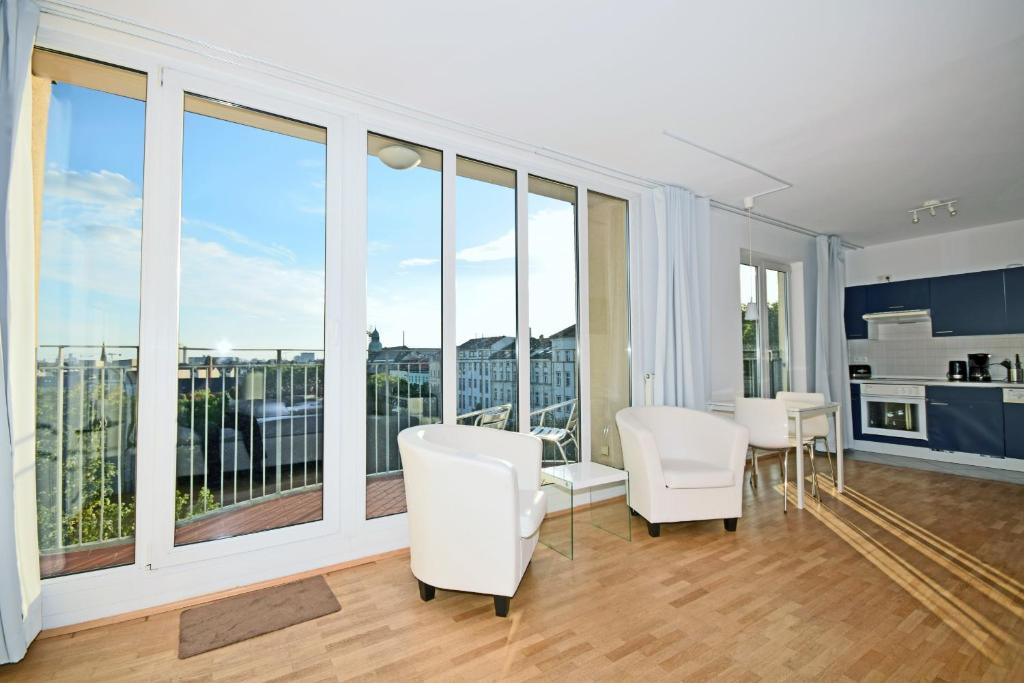 salon z białymi meblami i dużymi oknami w obiekcie Berlin Habitat w Berlinie