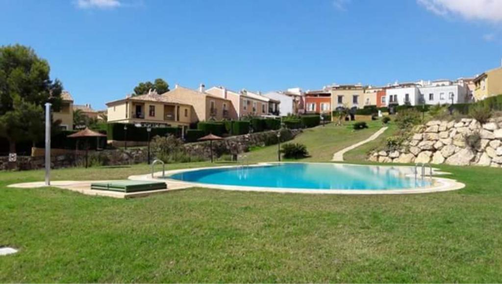 a swimming pool in the middle of a yard with houses at Benidorm holiday rental in Cala de Finestrat
