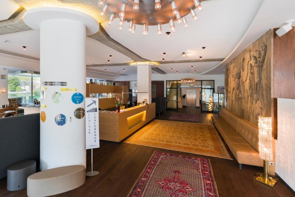 a lobby of a store with a rug and a chandelier at At the Park Hotel in Baden