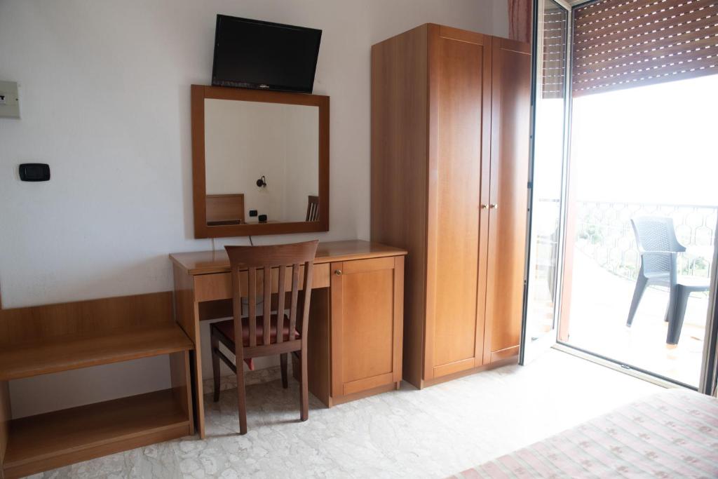 a room with a desk with a mirror and a chair at Hotel Royal in Coccorino