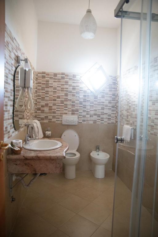 a bathroom with a sink and a toilet and a shower at Hotel Royal in Coccorino