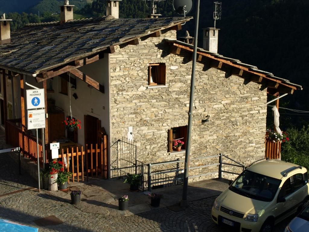 a small stone building with a car parked in front at B.&.B 44 in Ostana