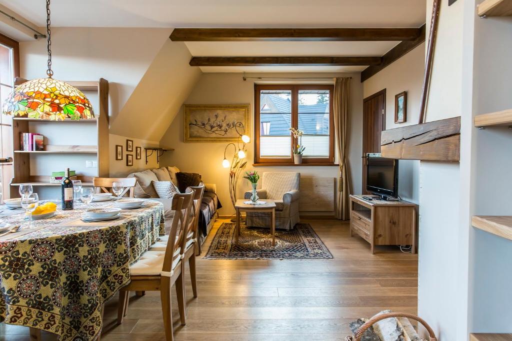 jadalnia i salon ze stołem i krzesłami w obiekcie Apartment Tiffany w mieście Nowe Bystre