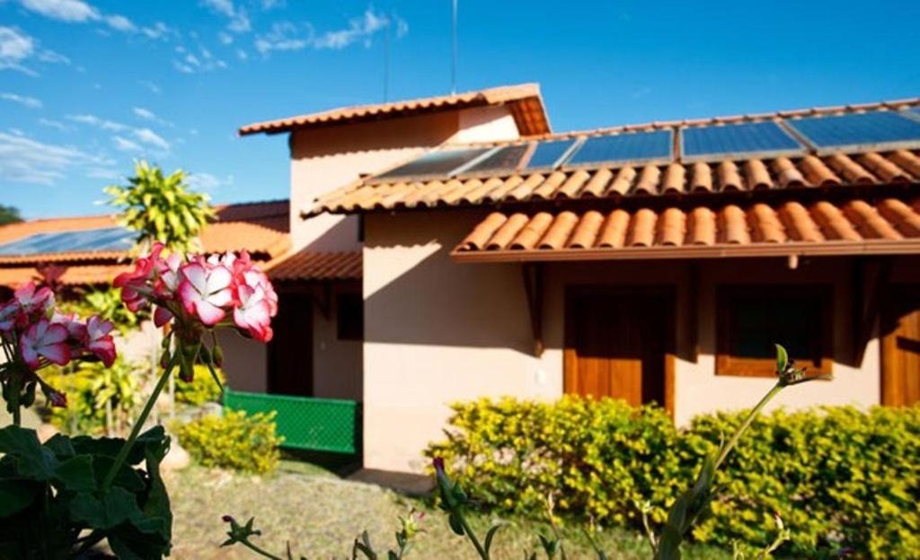 a house with a solar roof on top of it at Pousada Fazenda do Engenho in Serra do Cipo