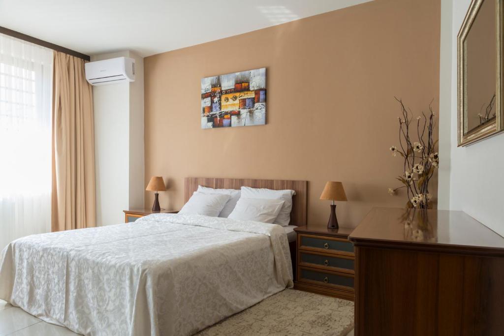 a bedroom with a bed with a white bedspread at Maxxy Apartments in Bucharest
