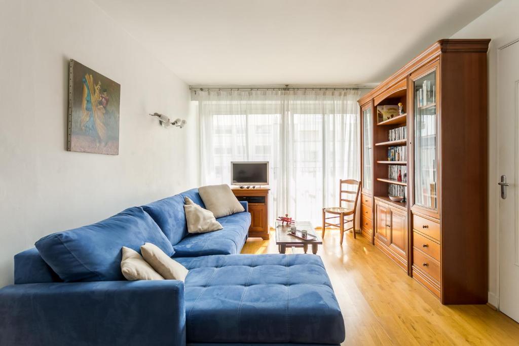 sala de estar con sofá azul y mesa en Lovely flat in Paris en París
