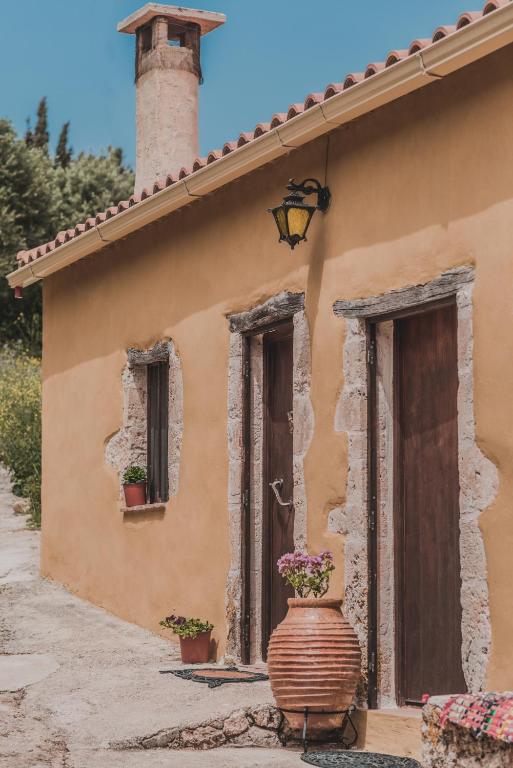 a building with a vase with flowers in front of it at La Casa Di Nonna in Koríthion