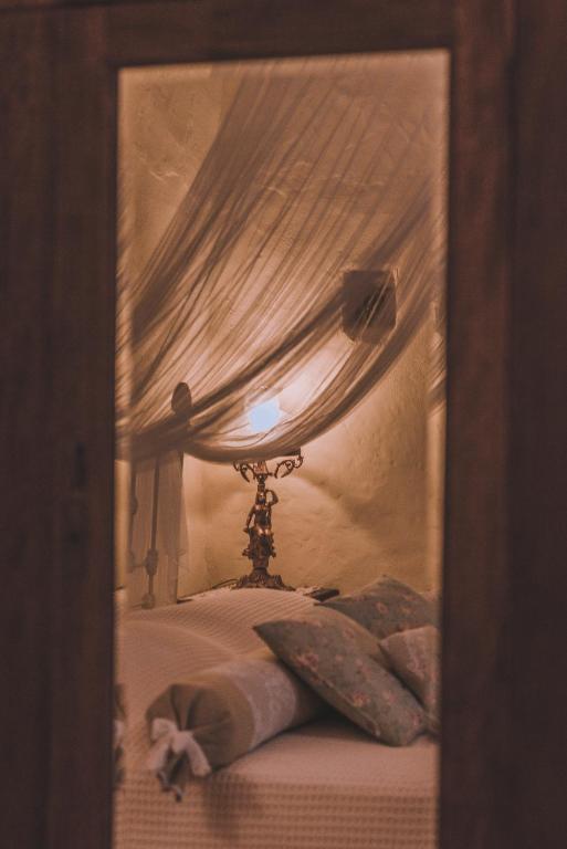 a bedroom with a bed with a canopy and a lamp at La Casa Di Nonna in Koríthion