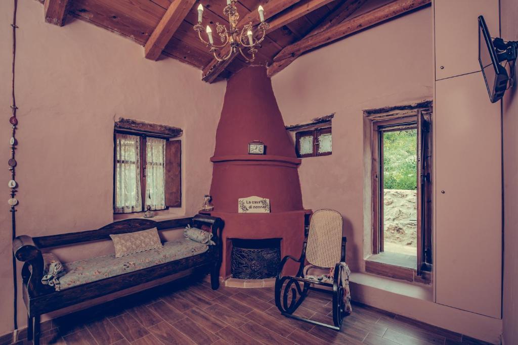 a room with a fireplace and a bed and a chair at La Casa Di Nonna in Koríthion