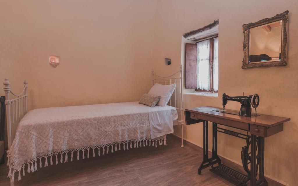 a bedroom with a bed and a sewing machine on a table at La Casa Di Nonna in Koríthion