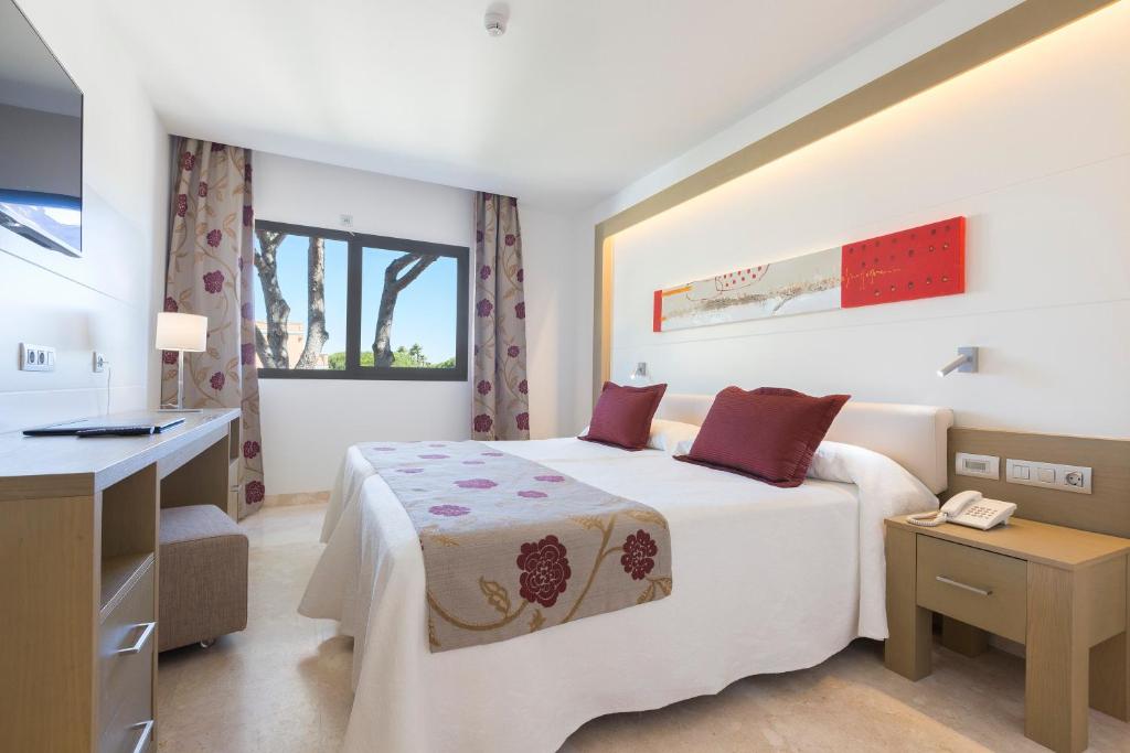 a hotel room with a bed and a desk at Hipotels Barrosa Garden in Chiclana de la Frontera