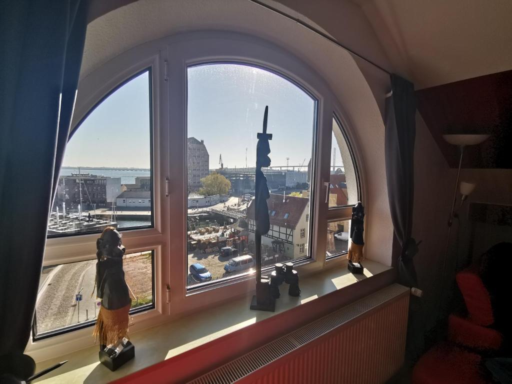ein Fenster mit Statuen in einem Zimmer mit Aussicht in der Unterkunft Apartments am Sund in Stralsund