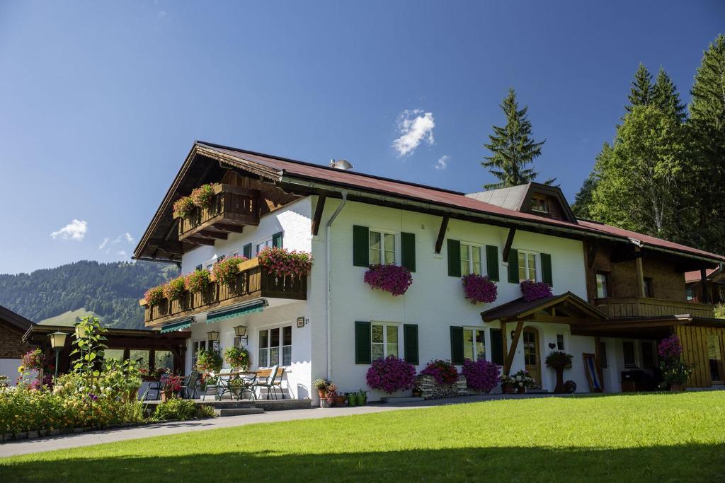 a large white house with flowers on the balconies at Gästehaus Auerstüble in Balderschwang