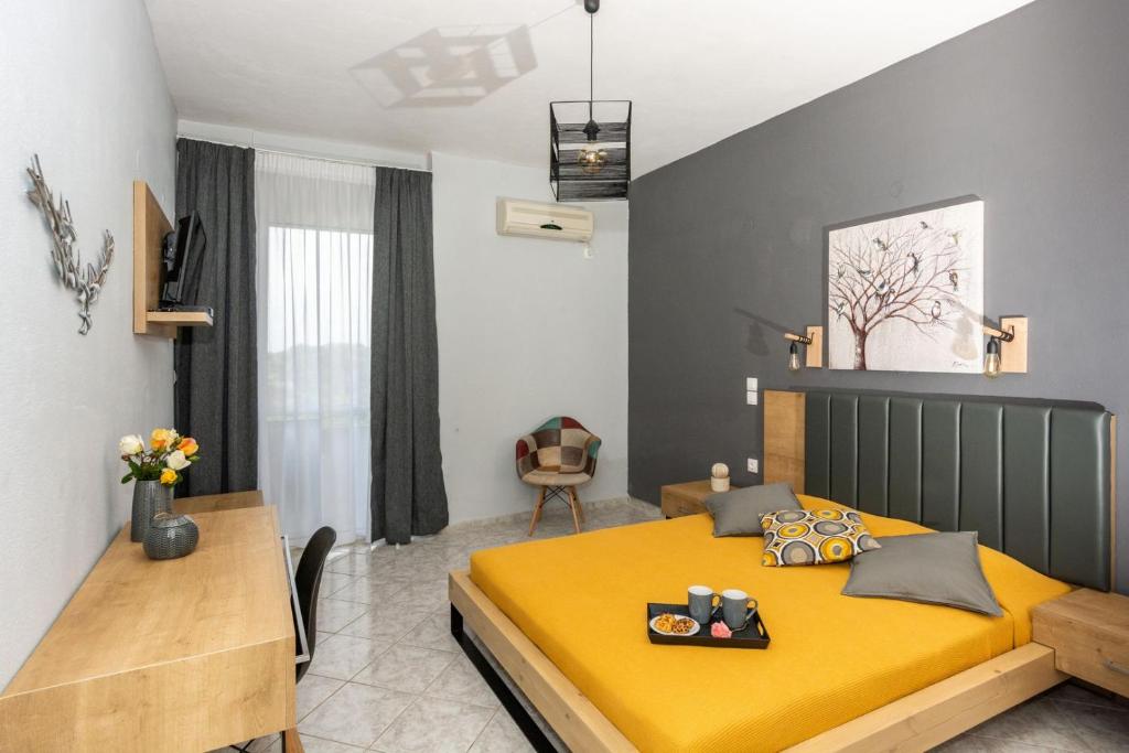 a bedroom with a yellow bed and a desk at Horizon Studios - Apartments in Rodakino