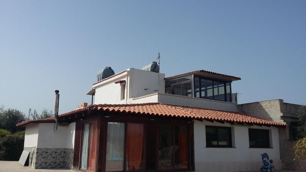 Casa blanca con balcón en la parte superior. en Casa vacanze Giosuè en Noto Marina