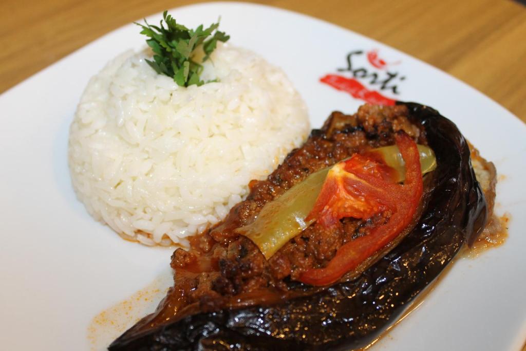 a white plate of food with rice and meat at Yeşilyurt Residence in İzmir