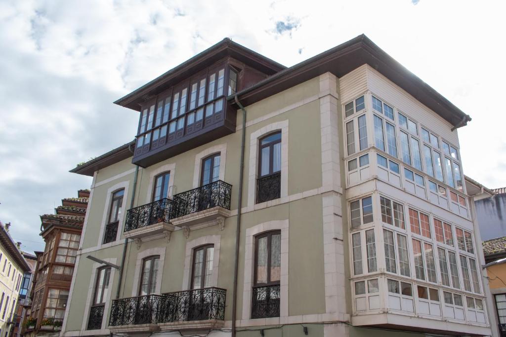 a large white building with balconies on a street at APARTAMENTOS CASINO in Llanes