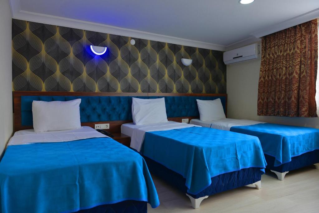 イスタンブールにあるHotel Marina Cityの青いシーツが備わるベッド2台付きの部屋