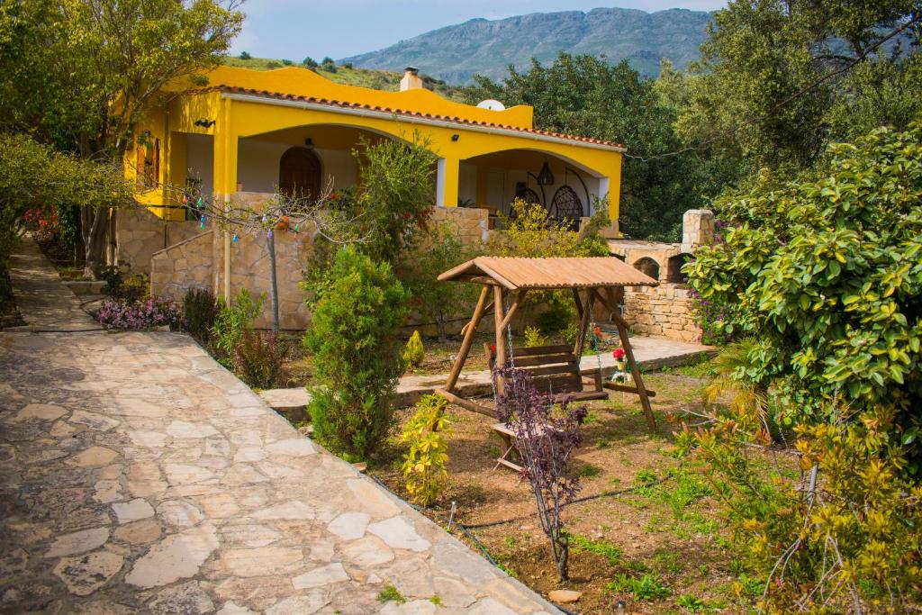 een geel huis met een tafel in een tuin bij Villa-Maria in Triopetra