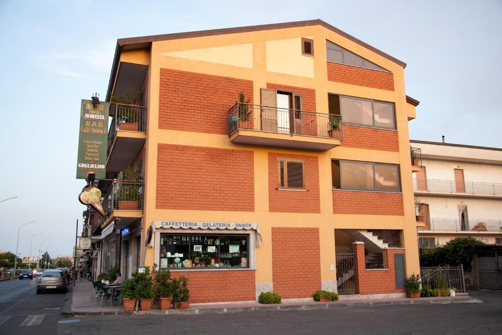 a orange brick building on the side of a street at Caffè Nuovo 2 Holiday Rooms in Trappitello