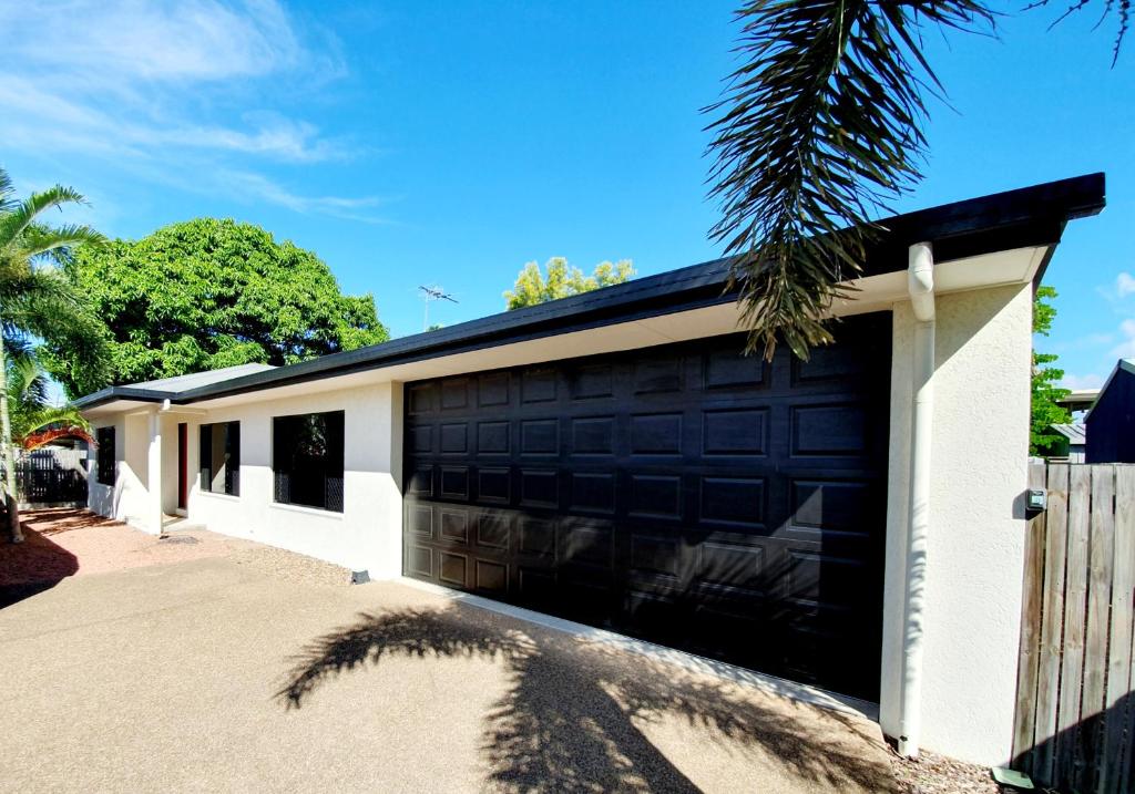 un garage avec un bâtiment noir et blanc dans l'établissement 3 bedroom central home, à Townsville