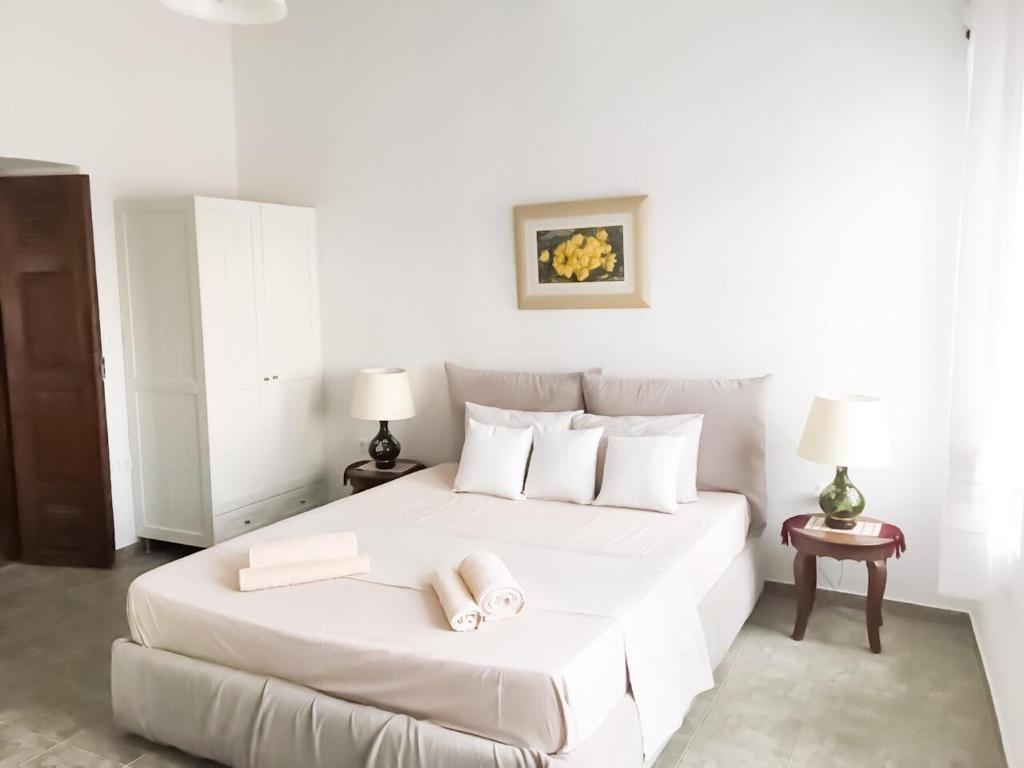 a bedroom with a white bed with two towels on it at Thomas Traditional House in Chora in Amorgos