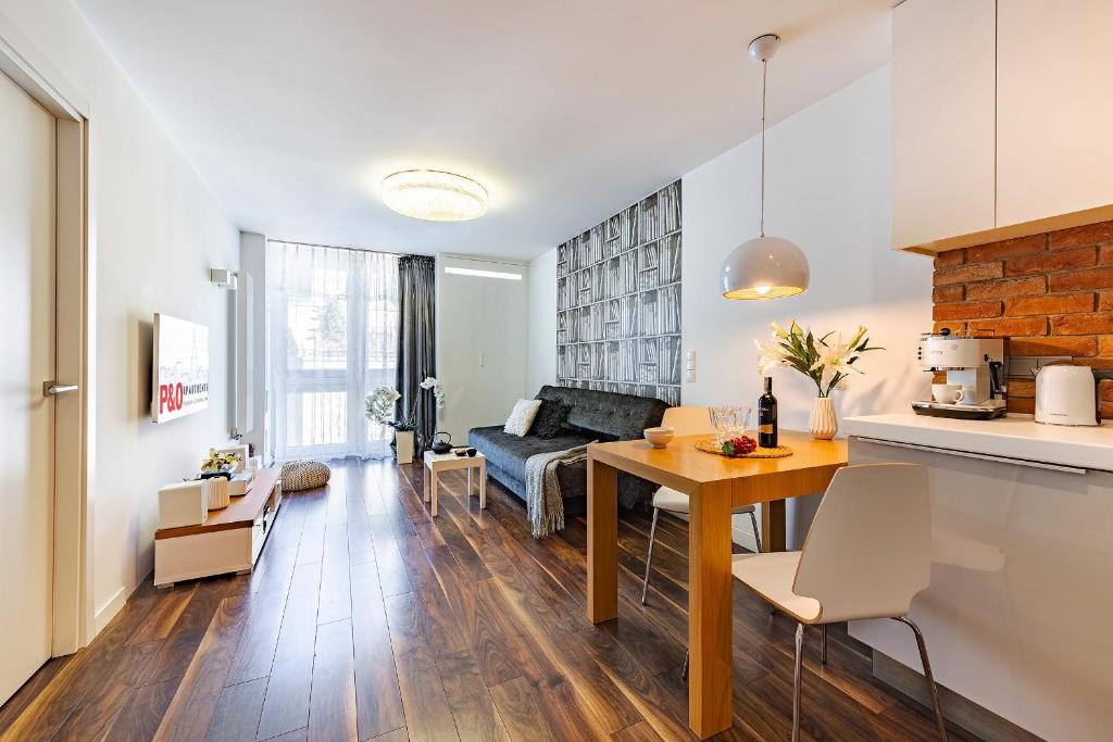 a kitchen and living room with a table and a couch at P&O City Center Apartments in Warsaw