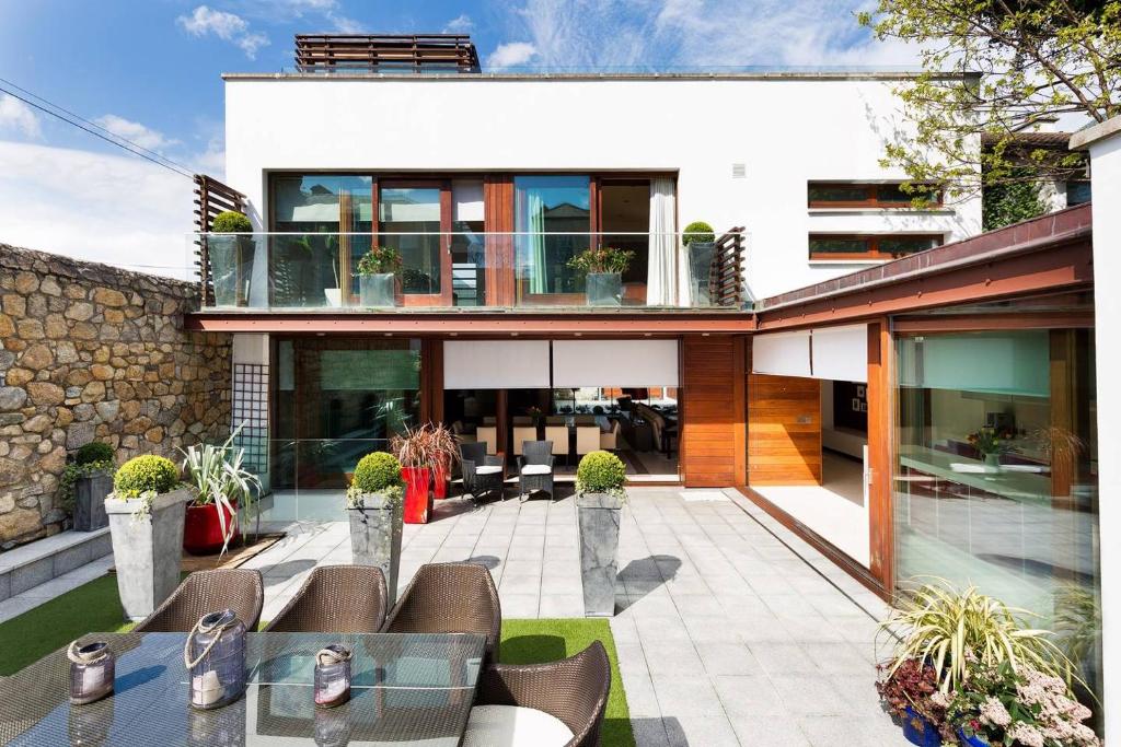 a house with a patio with chairs and tables at Modern Elegance, steps from the Aviva! Home Cinema in Dublin