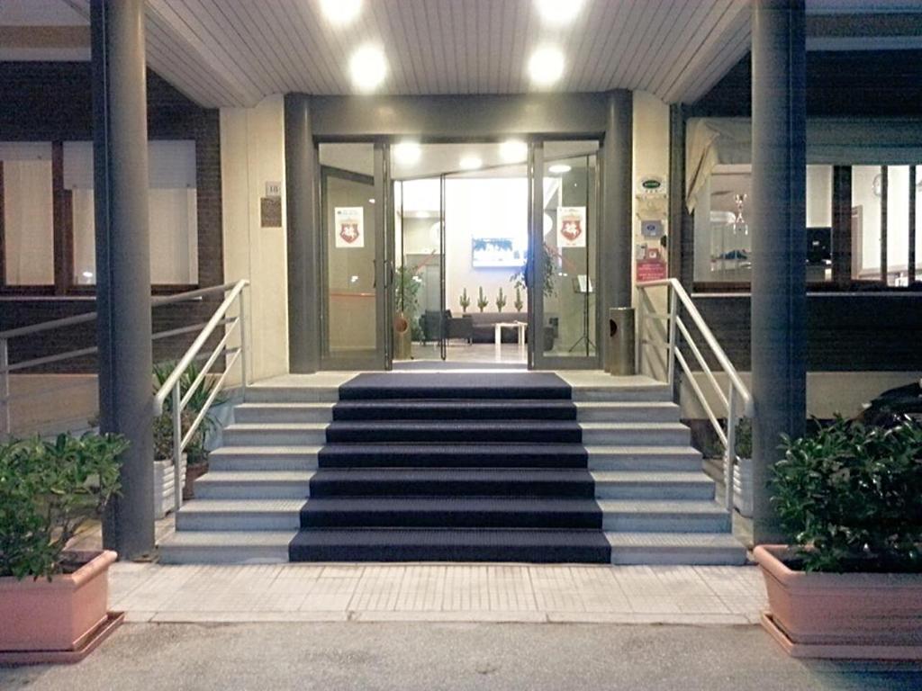 uma escada que leva a um edifício com um átrio em Hotel Touring em Falconara Marittima