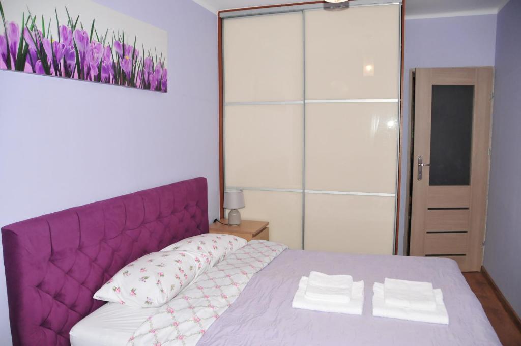 グダニスクにあるLuna Apart Gdańskのベッドルーム1室(紫色のベッド1台、枕2つ付)