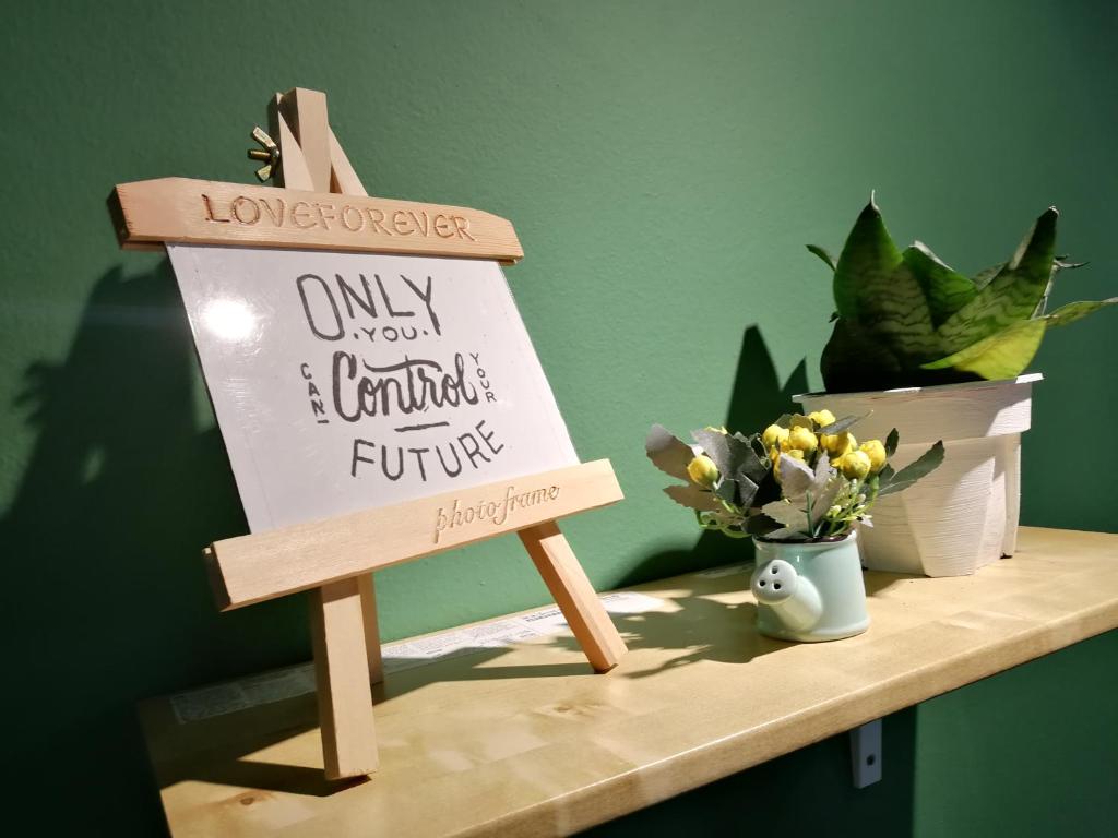 a sign sitting on top of a shelf with flowers at GVR Homestay 3 in Genting Highlands