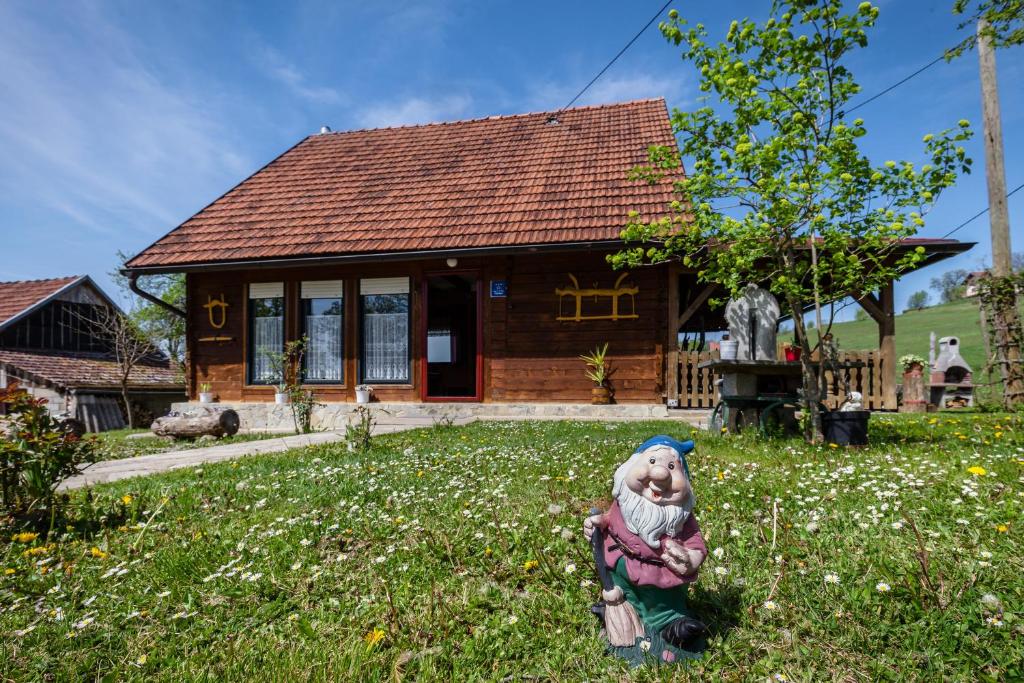 una pequeña casa con una estatua delante de ella en Peace of Nature ***, en Slunj