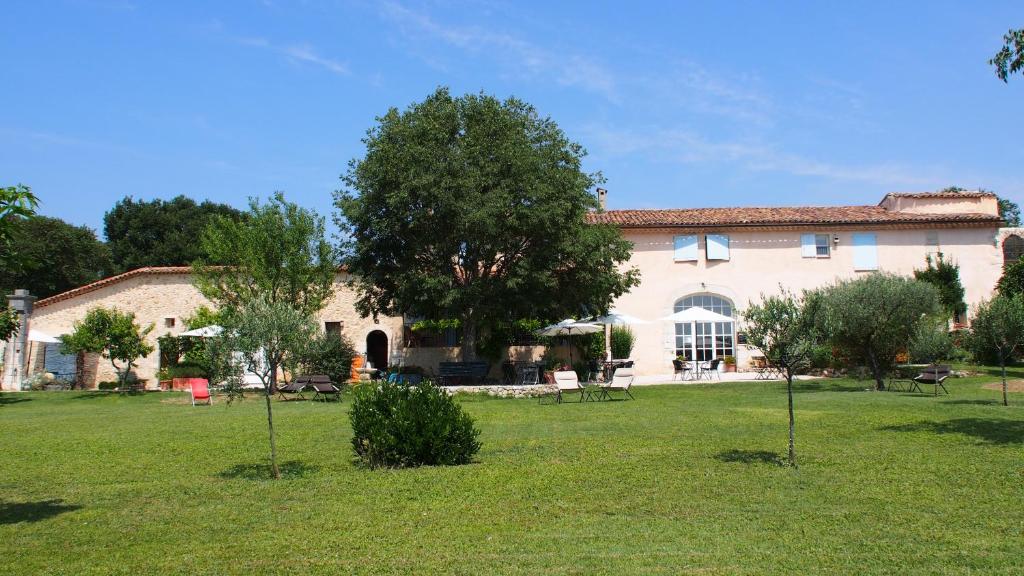 um grande edifício com árvores em frente em Hotel Le Moulin du Château em Saint-Laurent-du-Verdon