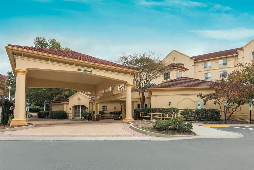 a hotel building with a large garage in front of a street at La Quinta by Wyndham Raleigh/Durham Southpoint in Durham