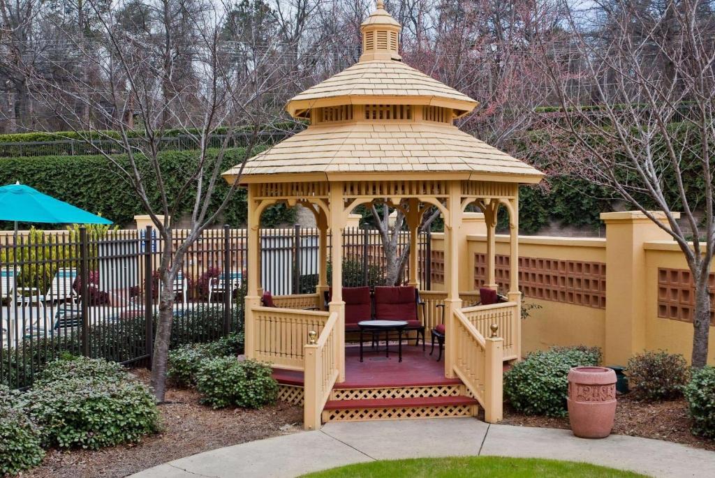 a gazebo in a garden with a table in it at La Quinta by Wyndham Greenville Haywood in Greenville